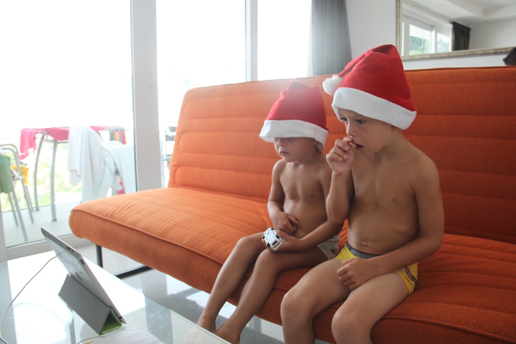 Alfred og Oskar ser julekalender iført nissehuer