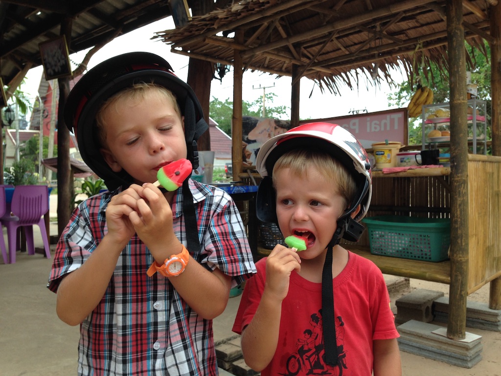 Oskar og Alfred spiser vandmelonis iført scooterhjelme