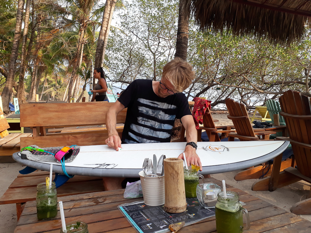 Rasmus vokser board til surf ved Banana Beach