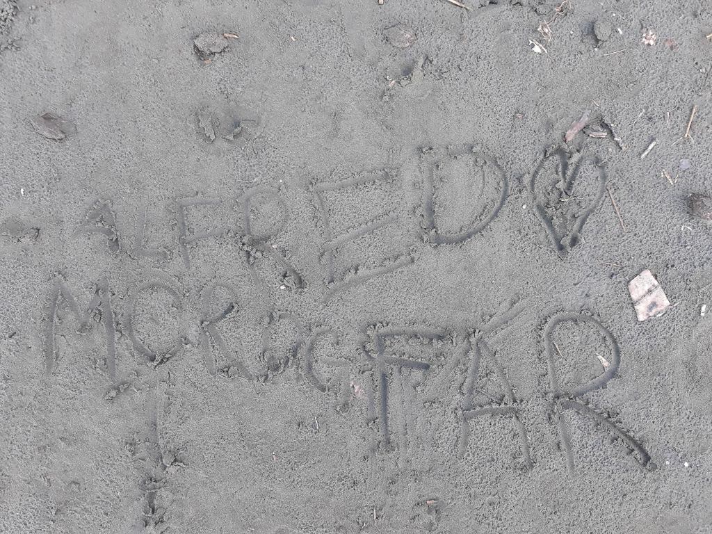 Alfred elsker mor og far skrevet i sandet
