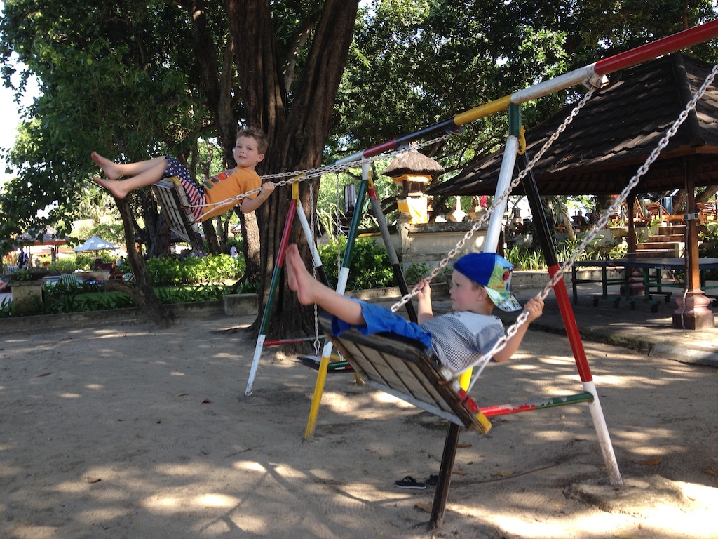 Oskar og Alfred gynger på legepladsen på Jayakarta Hotel