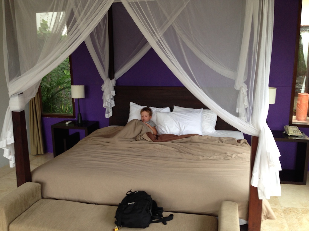 Oskar spiller iphone i sengen i Villa Aamoda, Echo Beach