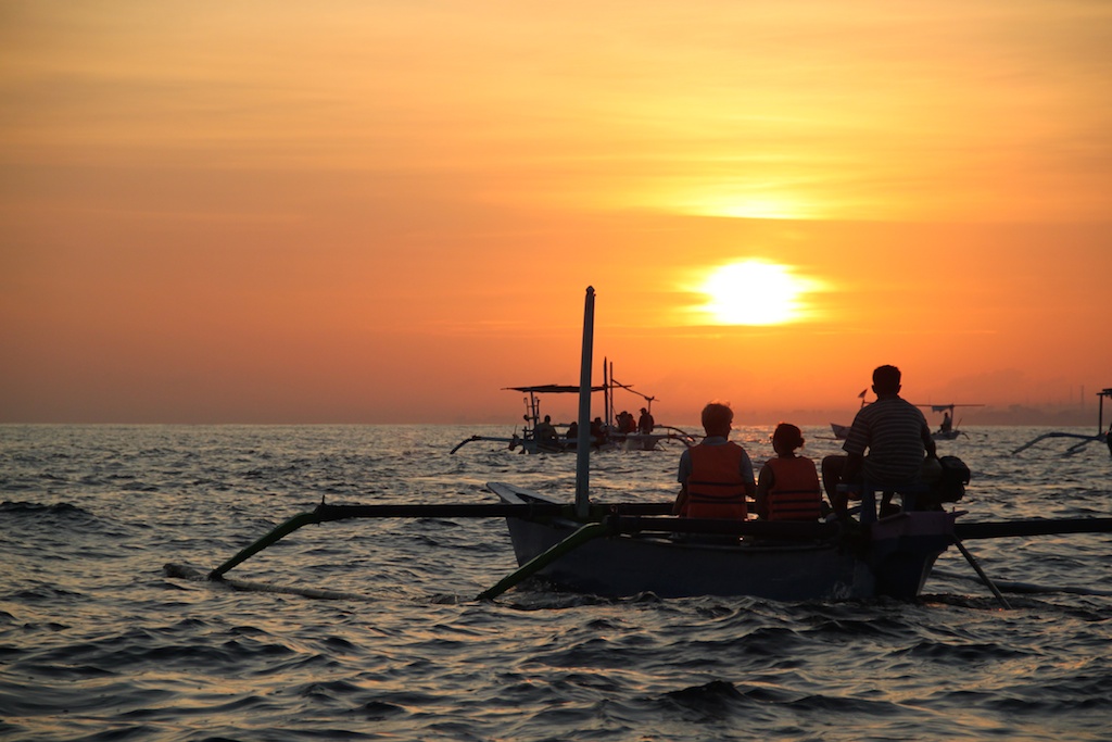 Oskar, Rasmus, Alfred og Helene i solopgangen i en outrigger-kano på delfinsafari