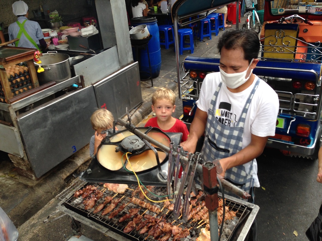 Alfred og Oskar kigger på tilberedning af grilspyd på gaden i Bangkok