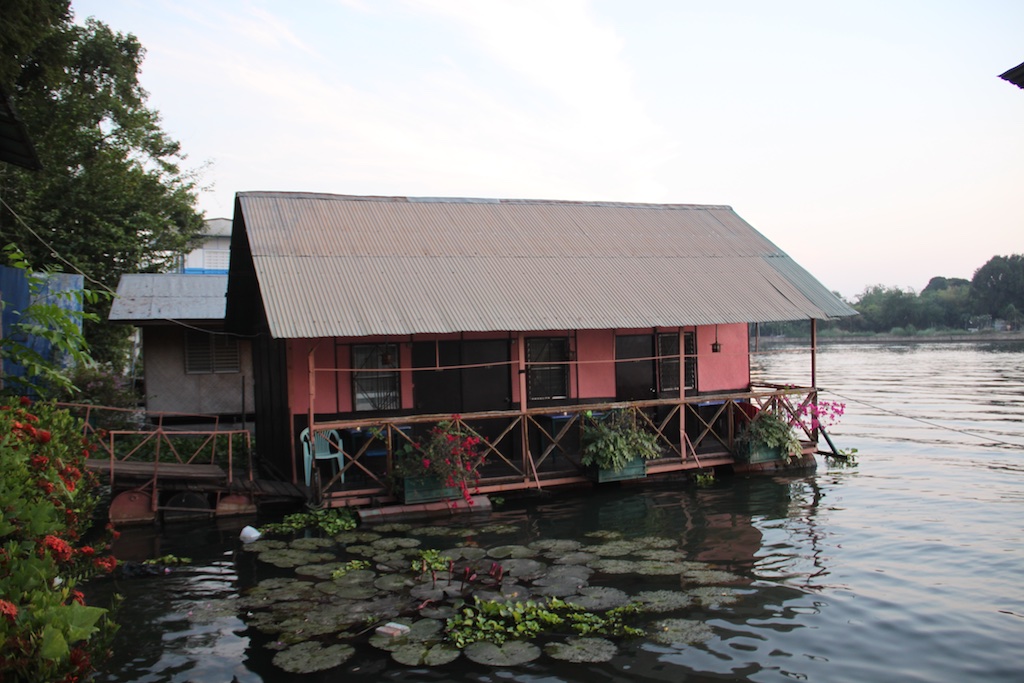 Lotus blomster foran et flydende hus på River Kwai