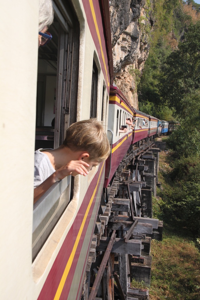 Oskar kigger ud af vinduet, mens toget kører på broen langs klippesiden
