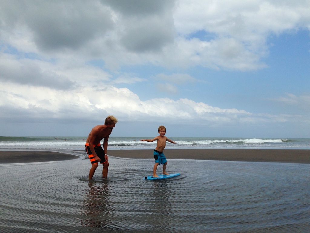 Rasmus og Oskar øver sig i at stå op på et boogie board i vandkanten ved Echo Beach