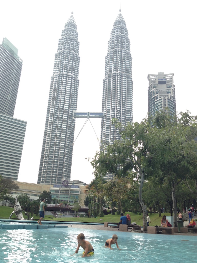 Oskar og Alfred leger i springvandet i parken foran Petronas Towers