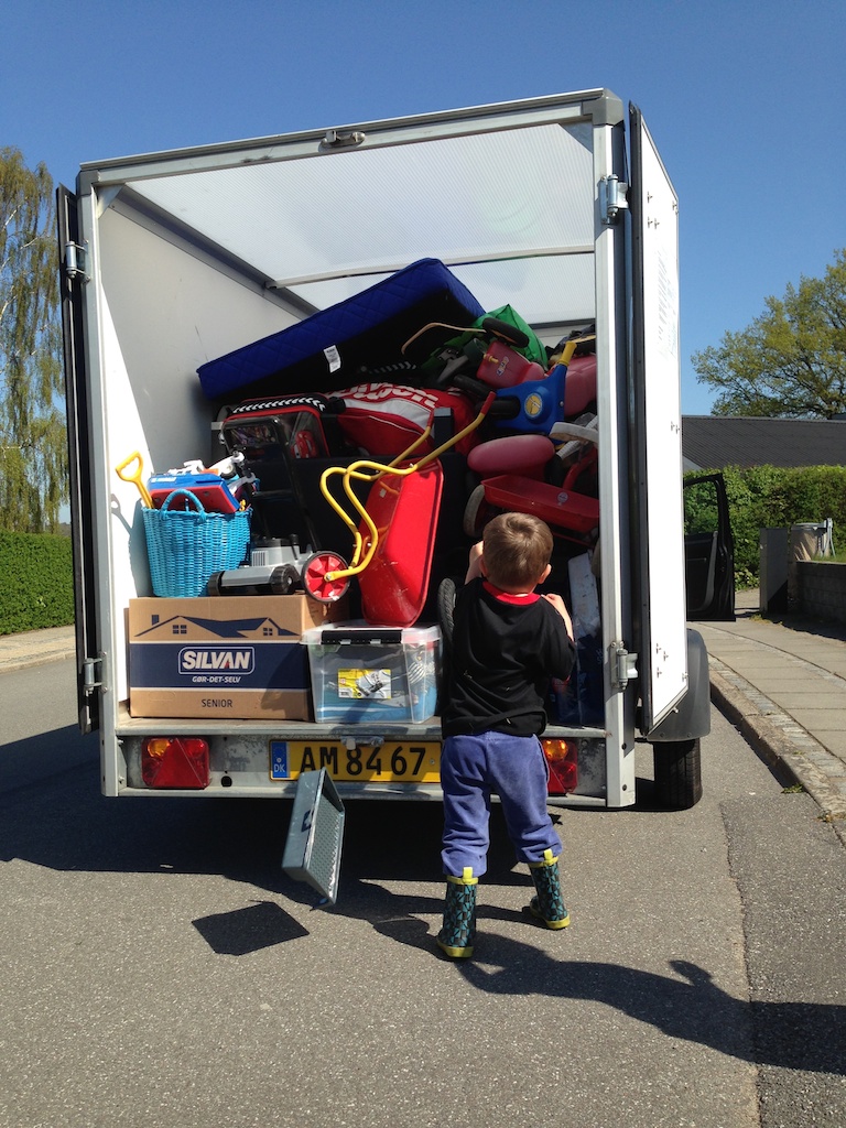 Alfred smider en malerbakke ind bag i den fyldte flyttetrailer på Rørbækvej