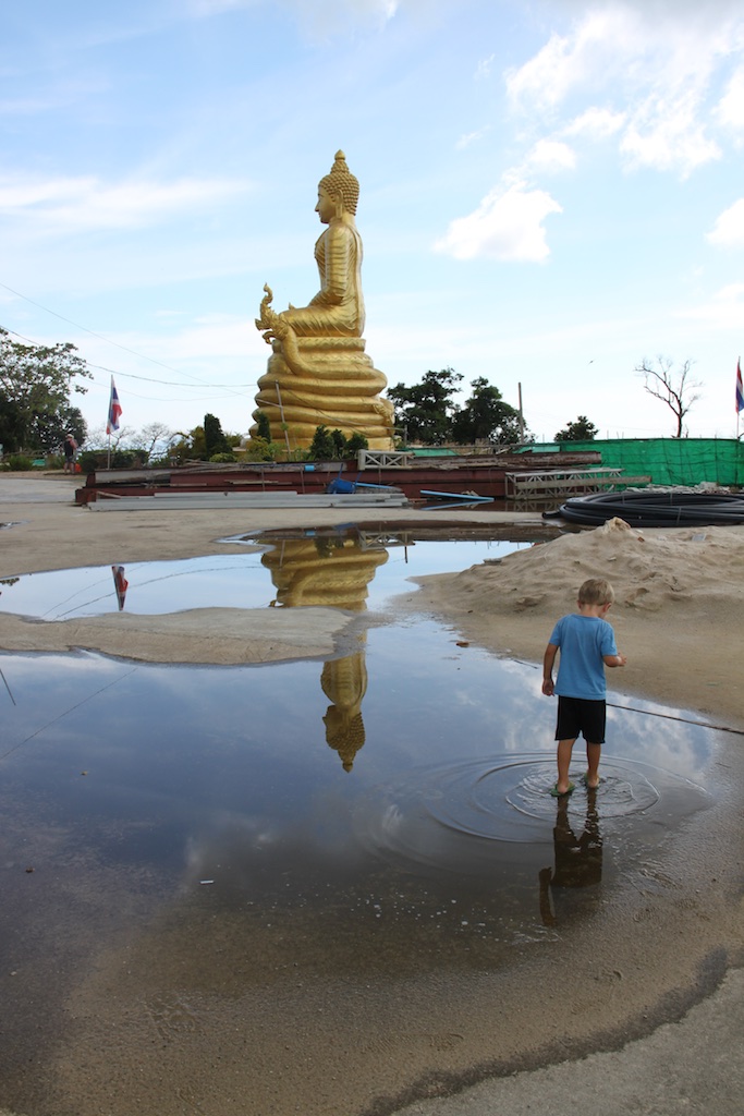 Alfred går i vandpyt foran en stor forgyldt Buddha