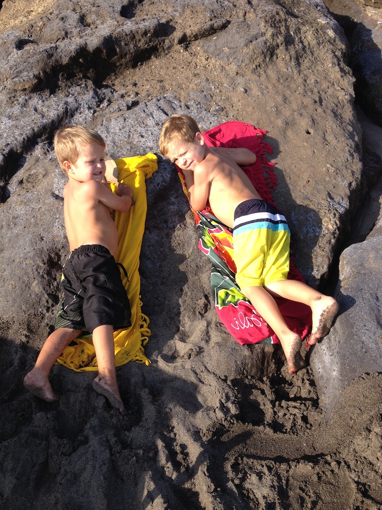 Alfred og Oskar ligger på saroner på klipperne ved Echo Beach