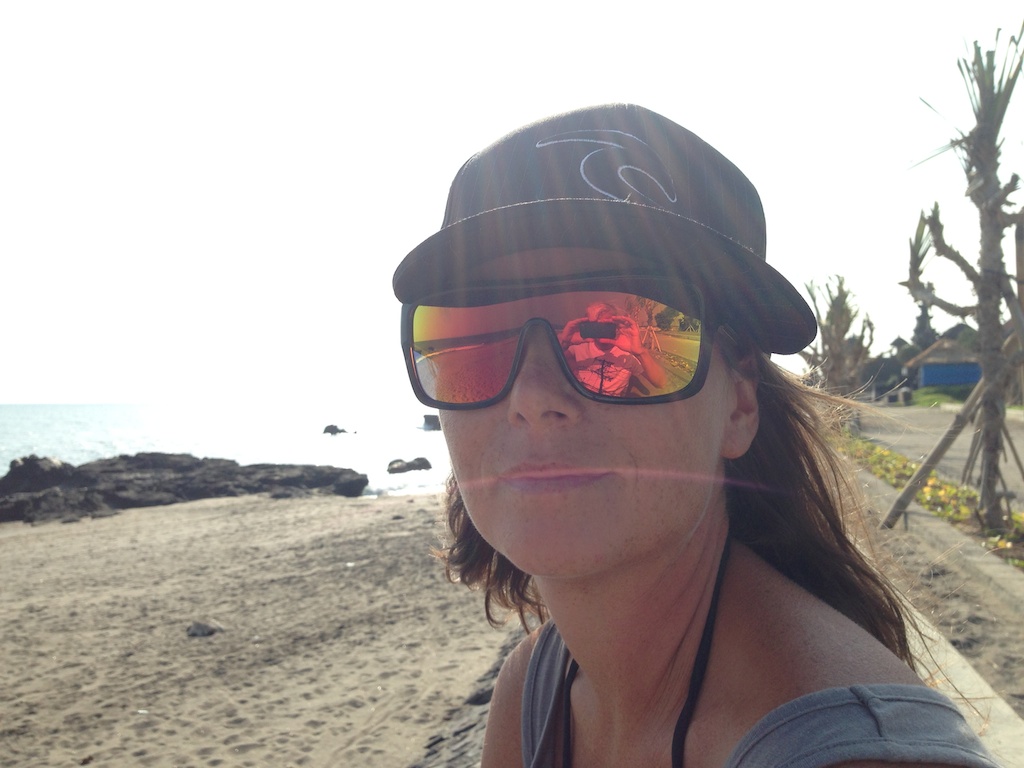 Helene med kasket og briller på stranden