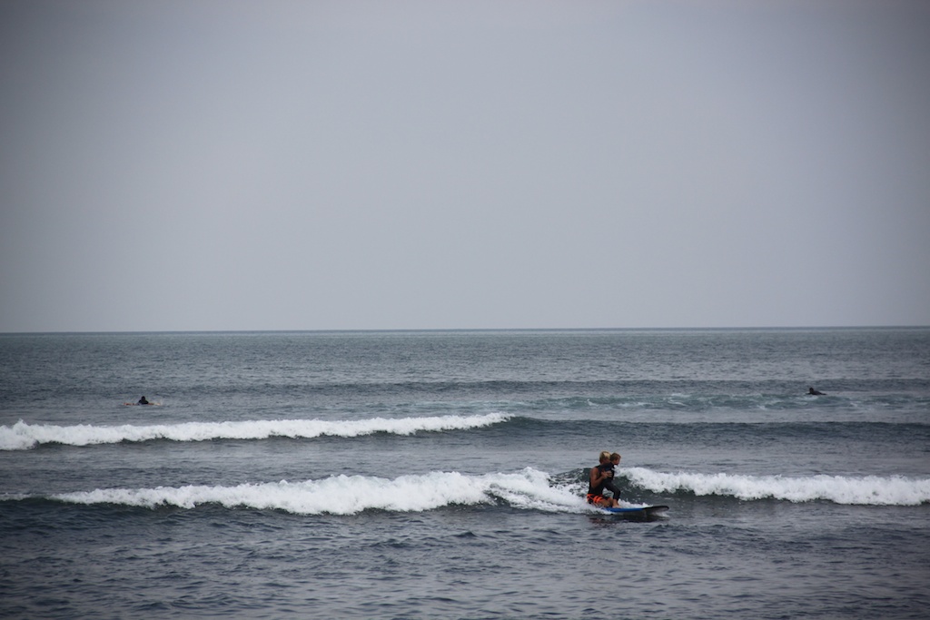 Rasmus og Oskar surfer tandem på et stort longboard