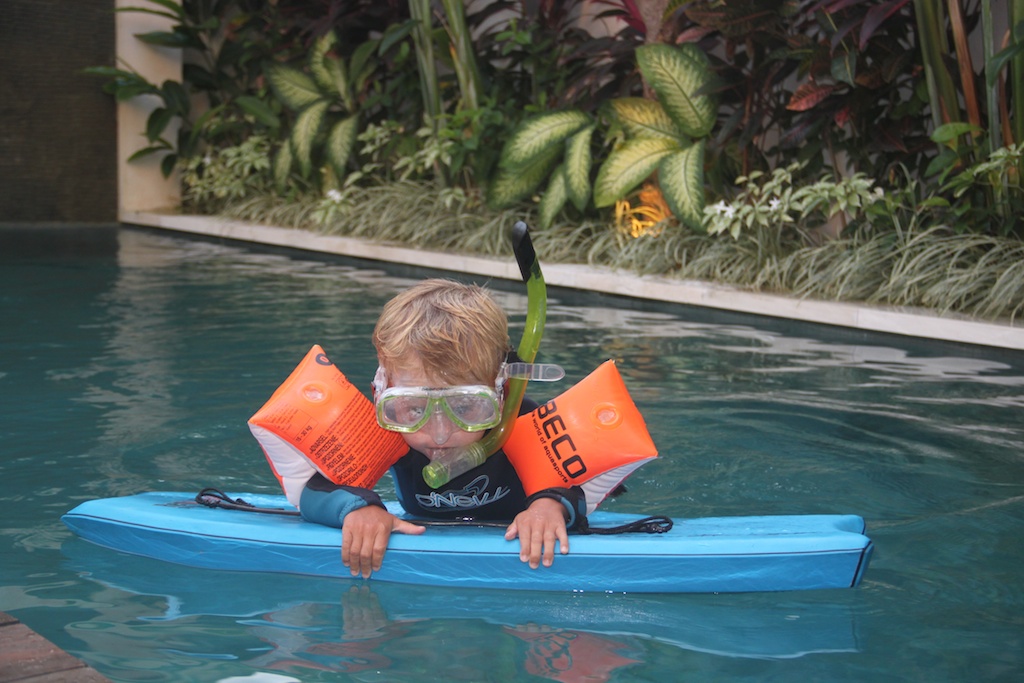 Alfred i poolen på boogie board iført våddragt, maske, snorkel og badevinger