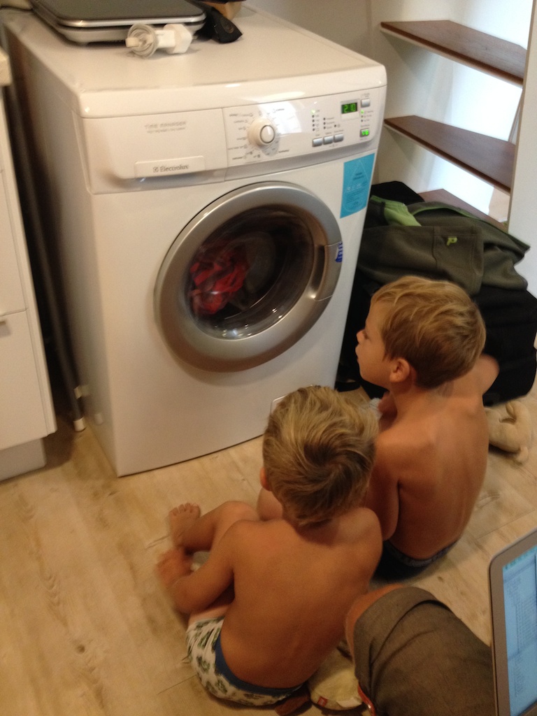 Oskar og Alfred kigger på vaskemaskinen, der vasker