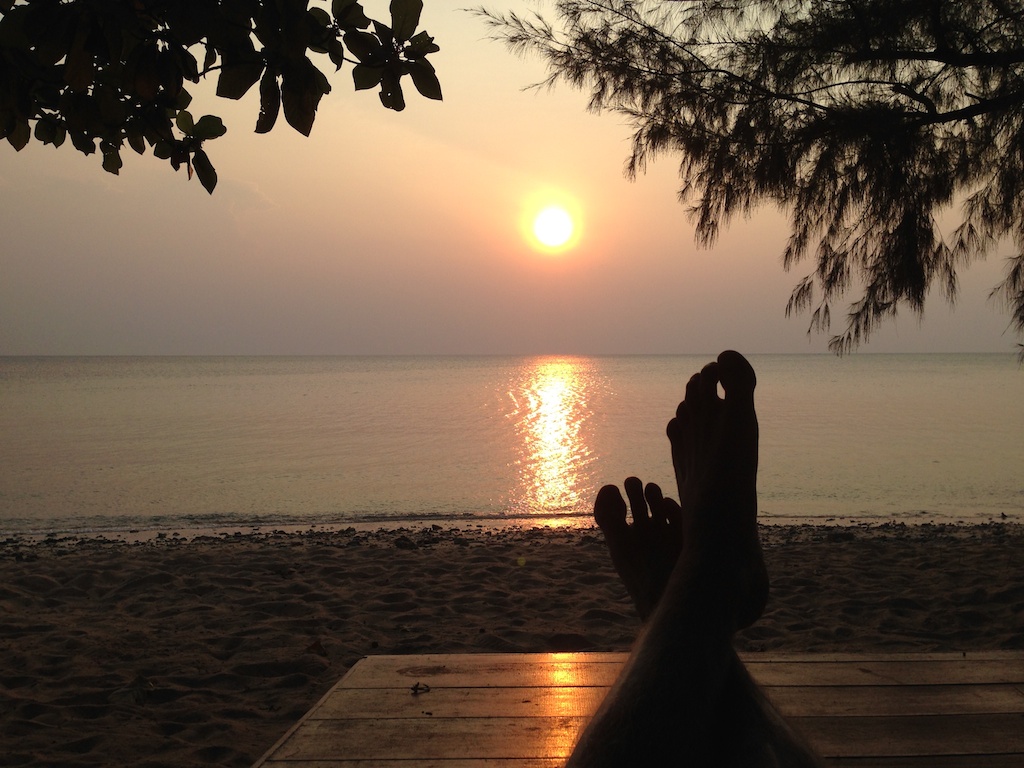 Rasmus nyder solnedgangen på stranden på Pulau Tioman