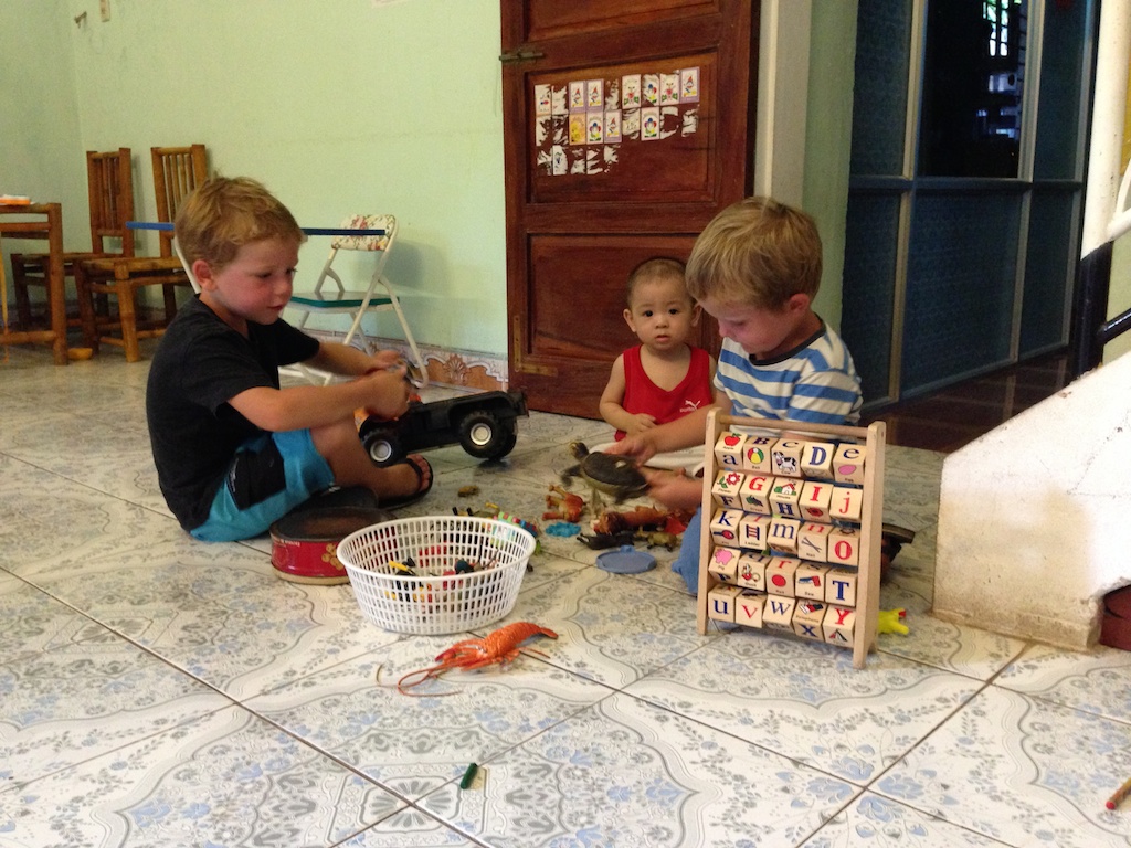 Oskar og Alfred leger med et lille lokal baby på en restaurant i Dong Hoi, mens hans mor tilbereder vores aftensmad