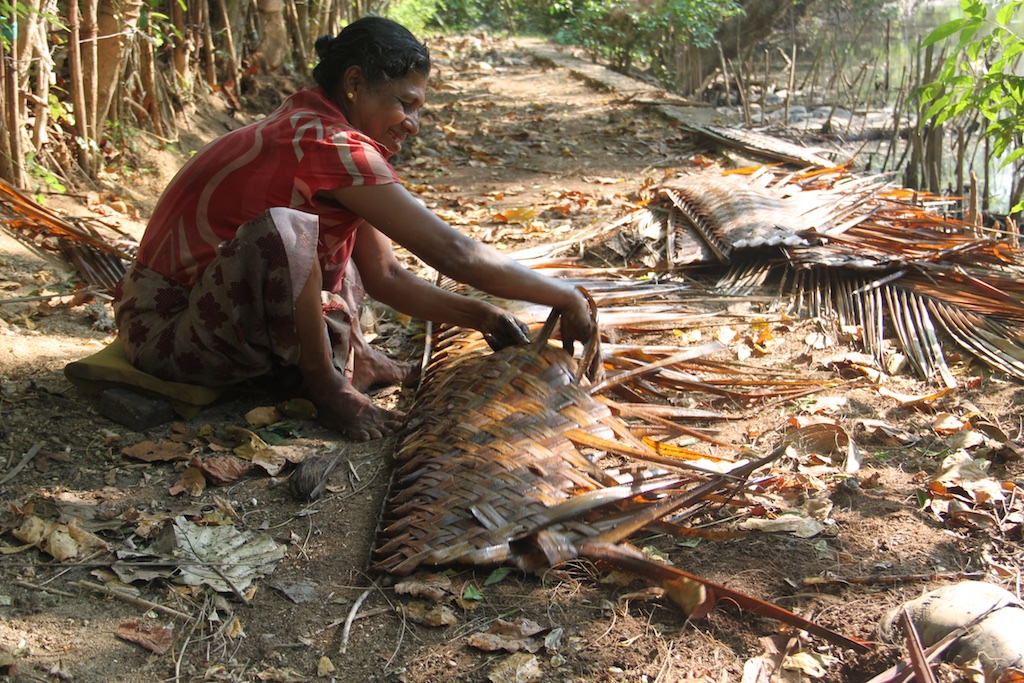 Srilankansk kvinde igang med at flette et Kokospalmeblad