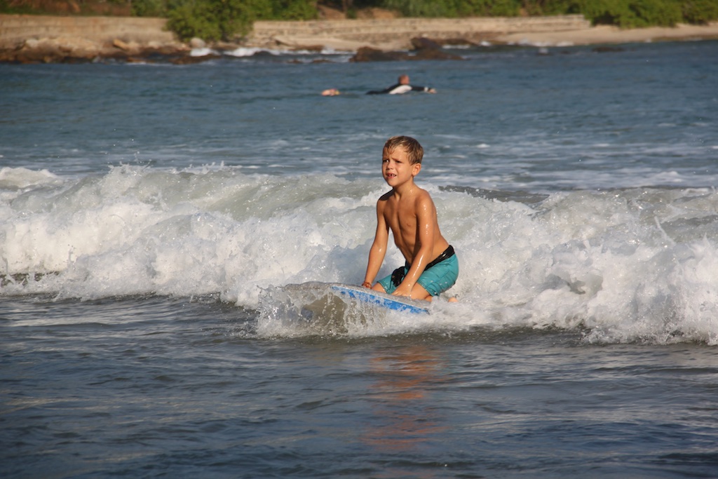 Oskar surfer siddende på knæ på et boogieboard